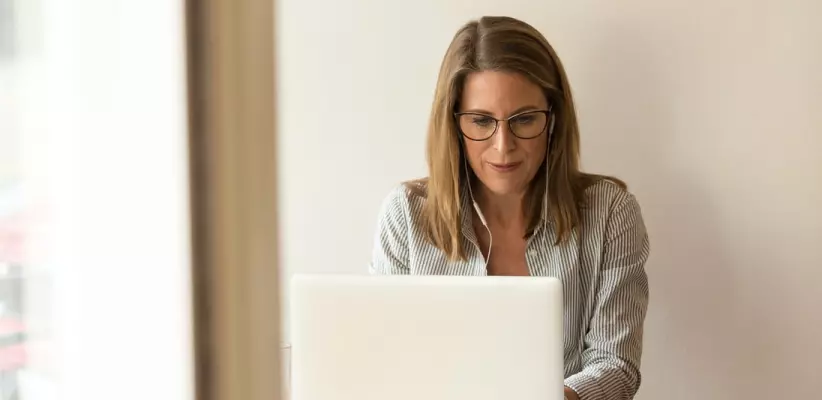 A woman works at her laptop